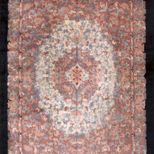 Plush scalloped rug featuring an ornate floral medallion pattern in rose, cream, and muted blue on a dark ground.