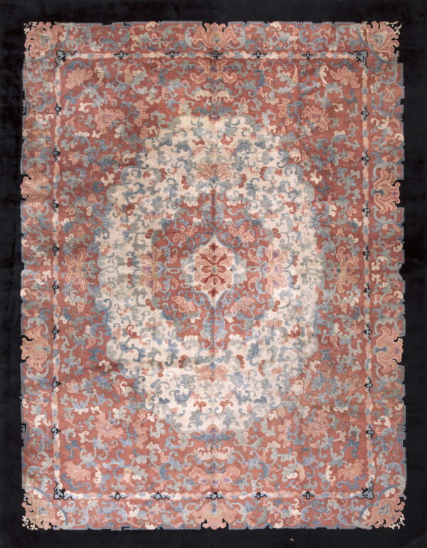 Plush scalloped rug featuring an ornate floral medallion pattern in rose, cream, and muted blue on a dark ground.