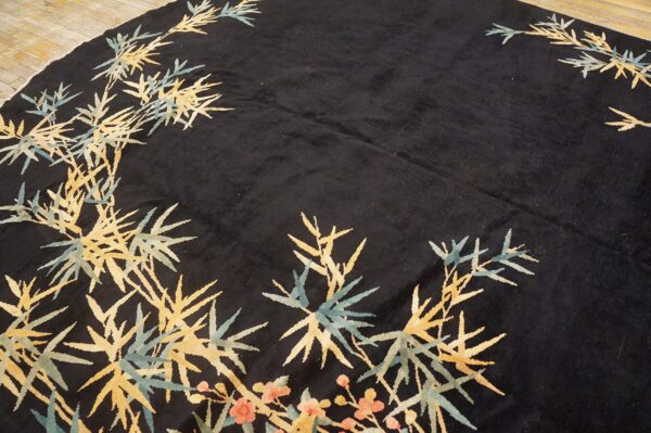 Dark pile rug featuring gold and teal bamboo and coral floral motifs on wood flooring.