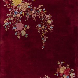 Deep red rug featuring lush floral sprays of yellow, pink, and blue trailing from the corners.