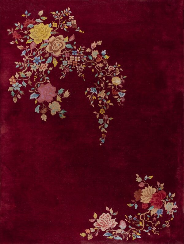 Deep red rug featuring lush floral sprays of yellow, pink, and blue trailing from the corners.
