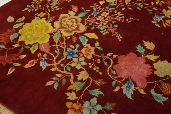 Deep burgundy rug featuring an all-over floral pattern with yellow, tan, blue, and pink accents.