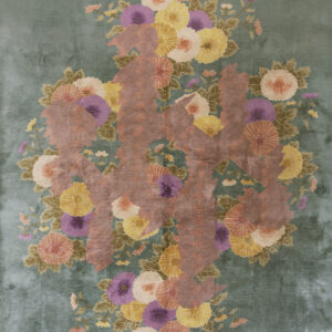 Low-pile teal rug with a large arrangement of multicolored flowers and stylized reddish-brown foliage.