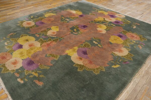 Deep green floral rug displaying large yellow, purple, and peach flowers on wooden planks.