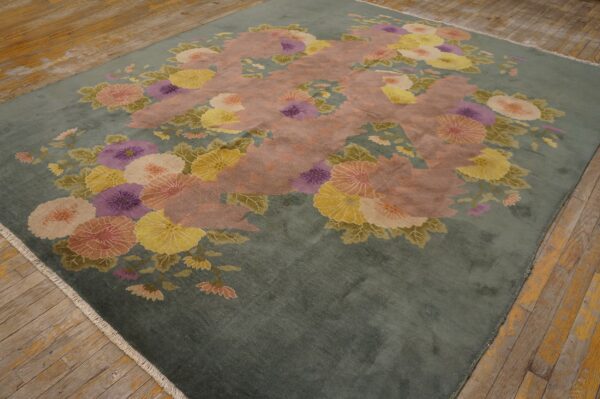 Plush green rug with pink, yellow, and lavender flowers sits on distressed wood planks.