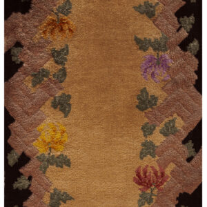 Gold high-pile rug featuring a black border, a shimmering mauve zig-zag pattern, and scattered multicolored flowers.