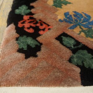 High-pile rug corner featuring bold blue, coral, green, and black floral patterns on distressed wood.