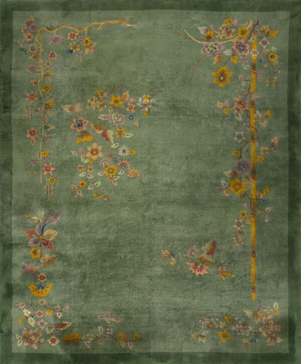 A sage green rug with a dark green border and colorful floral motifs in the corners.