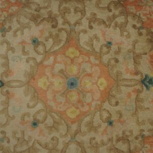 Close-up of ornate floral scrollwork rug in tan, brown, peach, yellow, and blue accents.