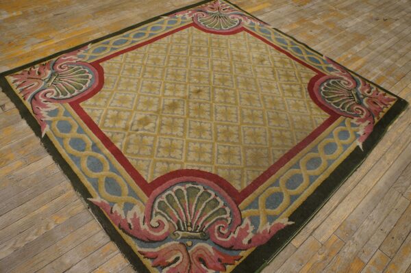 Gold diamond lattice rug with detailed pink and blue shell borders sits atop worn wooden floor planks.