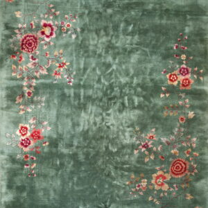 A lustrous green rug featuring corner sprays of crimson, pink, and cream floral vines around a central field.