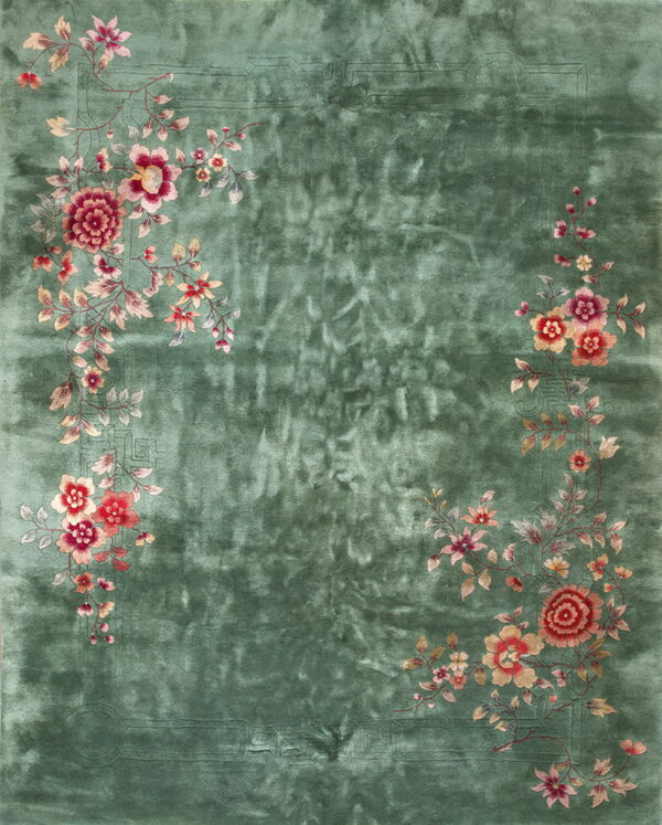 A lustrous green rug featuring corner sprays of crimson, pink, and cream floral vines around a central field.