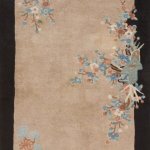 Beige rug featuring sprawling blue and pink blossoms, framed by wide, solid dark brown side borders.