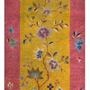 Rug with a bright pink border surrounding a yellow field featuring a large floral tree design.