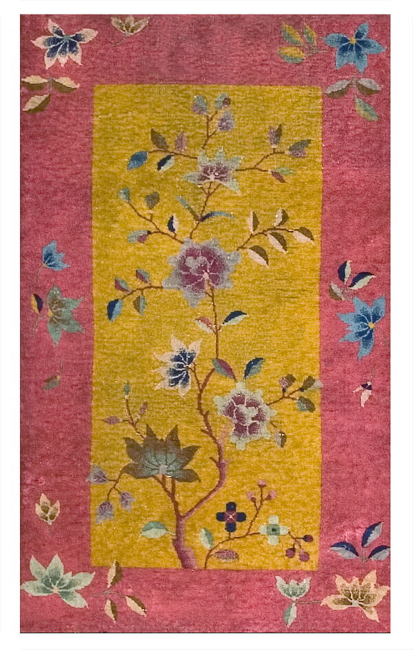 Rug with a bright pink border surrounding a yellow field featuring a large floral tree design.