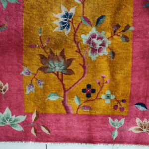 Golden yellow rug center with magenta border and multi-colored floral and leaf patterns on white tile.