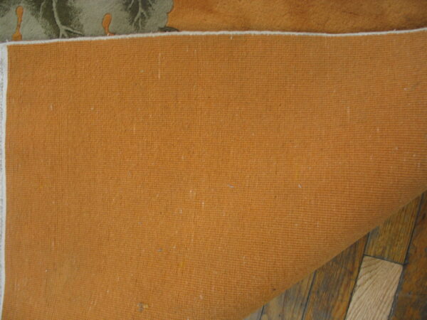 Close up of the ribbed terracotta rug backing resting on distressed brown hardwood planks.