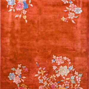 Plush rust rug with colorful floral sprays decorating the corners and edges.