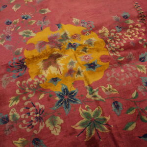 Magenta pile rug featuring a bold golden medallion surrounded by complex blue and green floral vines.