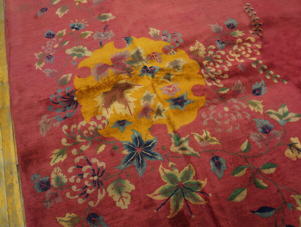 Magenta pile rug featuring a bold golden medallion surrounded by complex blue and green floral vines.