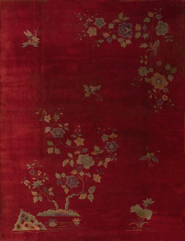 Deep crimson rug featuring an asymmetrical botanical pattern of gold, green, and purple flowers and butterflies.