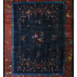 Navy blue area rug with detailed multi-colored floral vines and a rust red border design.
