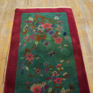 Teal runner with multi-colored blossoms and branches, framed by a burgundy border on distressed wood.