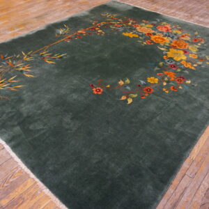 Dark green rug with a plush pile features bright bamboo and floral motifs on wood flooring.