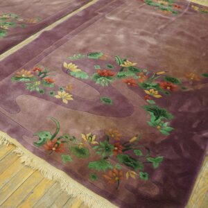 Velvety purple rug featuring carved orange and green floral designs sits on weathered hardwood flooring.