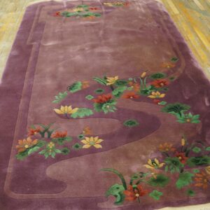 Plush purple rug featuring yellow, orange, and green water lilies on worn wooden floorboards.