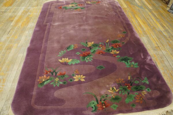 Plush purple rug featuring yellow, orange, and green water lilies on worn wooden floorboards.