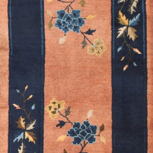 Navy blue borders frame a dusty salmon central panel with scattered blue and gold floral branches.