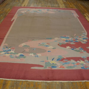 Large rug in deep pink and taupe with multicolored curvilinear floral designs on wood plank flooring.
