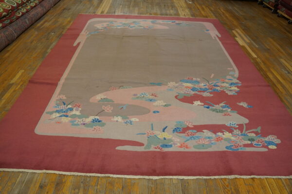 Large rug in deep pink and taupe with multicolored curvilinear floral designs on wood plank flooring.