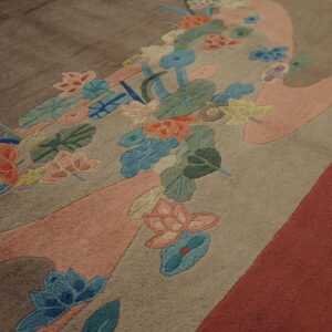 Colorful carved floral pattern overlaying large, flowing bands of pink, tan, brown, and reddish pile.