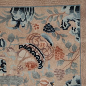 Plush, pale pink rug detail showing intricate blue, gray, and rust botanical patterns on a white tiled floor.