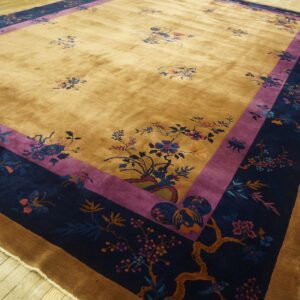 Golden yellow rug with detailed floral patterns and a wide navy and purple border on wood floors.