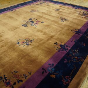 High-sheen tan rug with scattered florals and thick purple and navy botanical borders on hardwood.