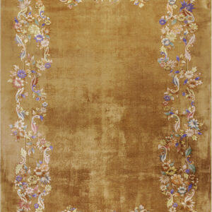 Amber rug with a distressed gold center and an ornate multicolored floral and vine border.