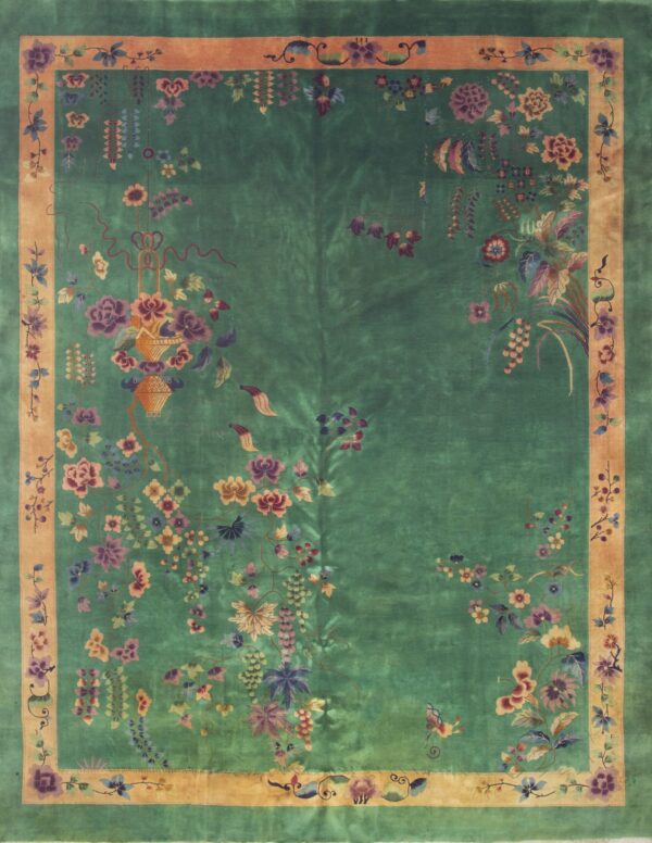 Emerald green rug with an orange border featuring dense, asymmetrical multicolor floral and vine patterns.