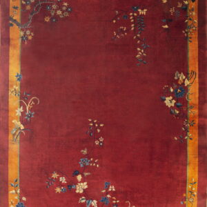 Deep red rug with a gold border and stylized blue and cream floral vines near the edges.