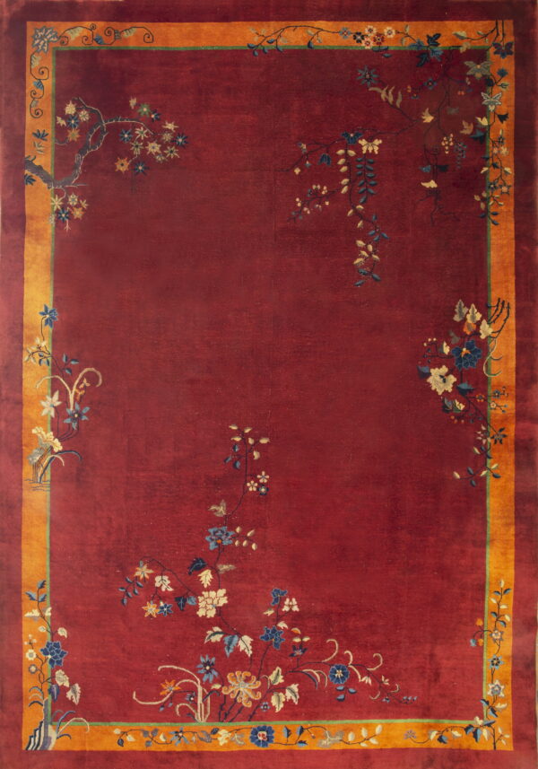 Deep red rug with a gold border and stylized blue and cream floral vines near the edges.