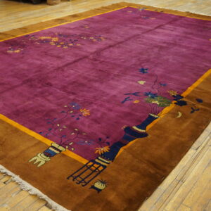 Bright magenta plush rug featuring vase and floral motifs, bordered in golden brown on wood planks.