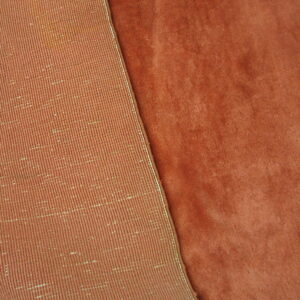 Plush rust colored rug pile folds back to show the tightly woven ribbed underside.