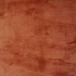 Low-pile rust rug showing color variation and shading next to distressed yellow painted hardwood floor.