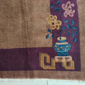 Brown plush rug corner shows a purple border with stylized yellow and pink floral vase motifs.
