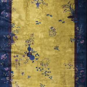 Gold field rug with a wide navy border featuring detailed flowers, vines, birds, and vases.