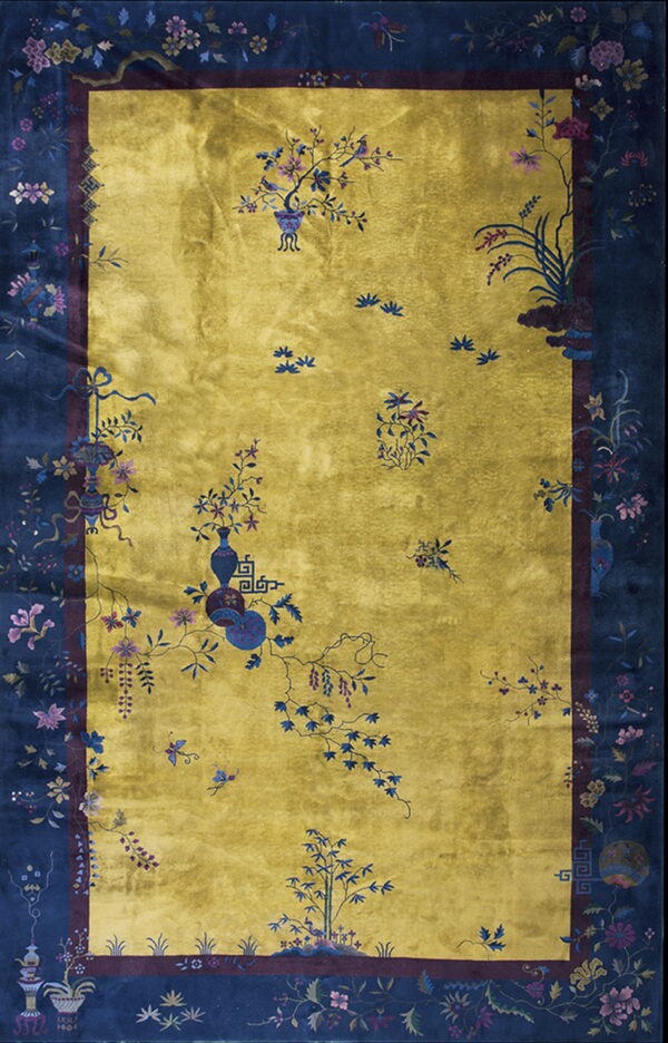 Gold field rug with a wide navy border featuring detailed flowers, vines, birds, and vases.