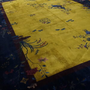 Plush chartreuse rug featuring scattered botanicals and a wide navy border on wood flooring.