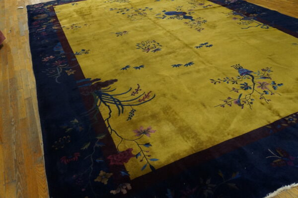 Plush chartreuse rug featuring scattered botanicals and a wide navy border on wood flooring.